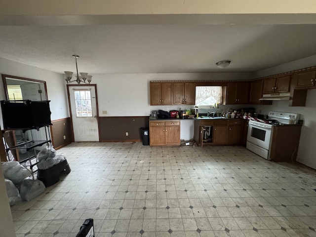 kitchen featuring sink, electric range, an inviting chandelier, and hanging light fixtures