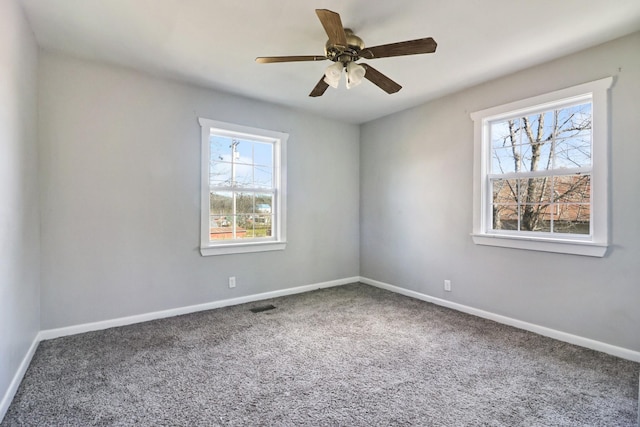 empty room featuring ceiling fan, carpet, and a wealth of natural light