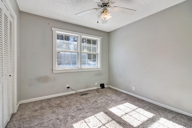 unfurnished bedroom featuring ceiling fan, light colored carpet, a textured ceiling, and a closet