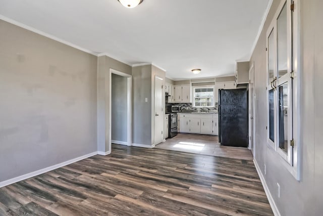 kitchen with black appliances, backsplash, dark hardwood / wood-style floors, and crown molding