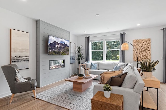 living room with a large fireplace and light hardwood / wood-style floors