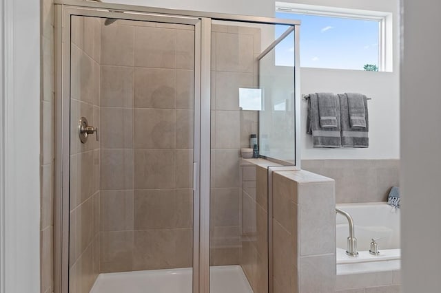 bathroom featuring shower with separate bathtub