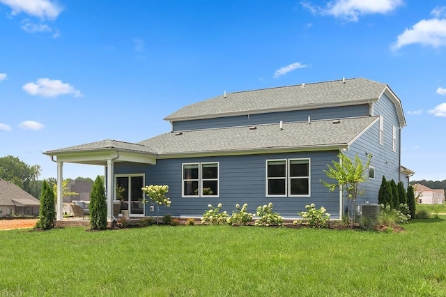 rear view of property with a lawn and central air condition unit