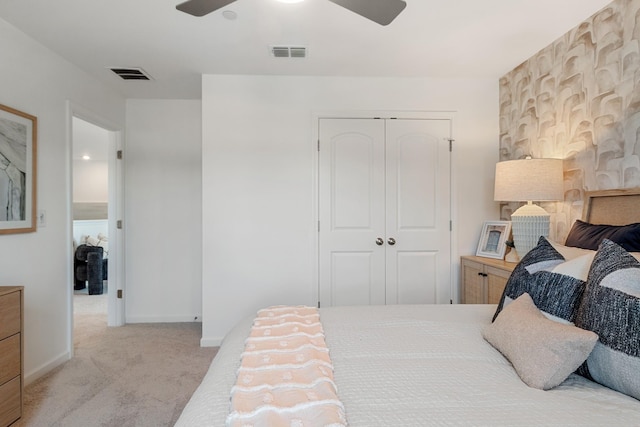 bedroom featuring a closet, light colored carpet, and ceiling fan