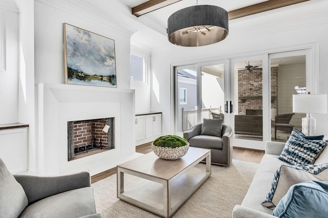 living room featuring ceiling fan, beamed ceiling, and light hardwood / wood-style flooring