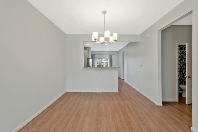 unfurnished dining area with light hardwood / wood-style flooring and a notable chandelier