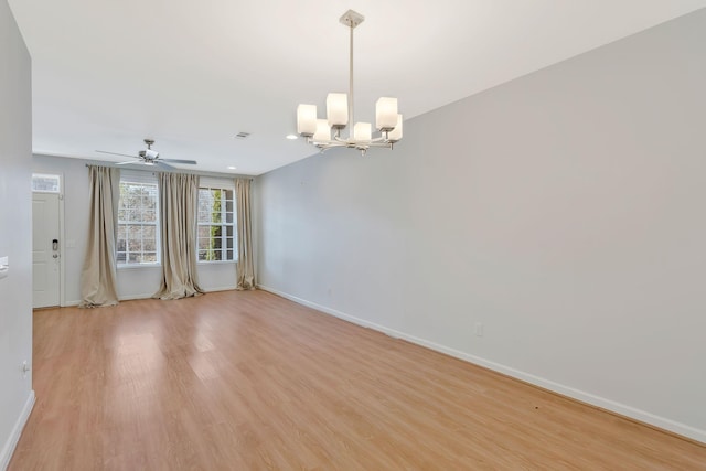 empty room featuring light wood-type flooring and a chandelier