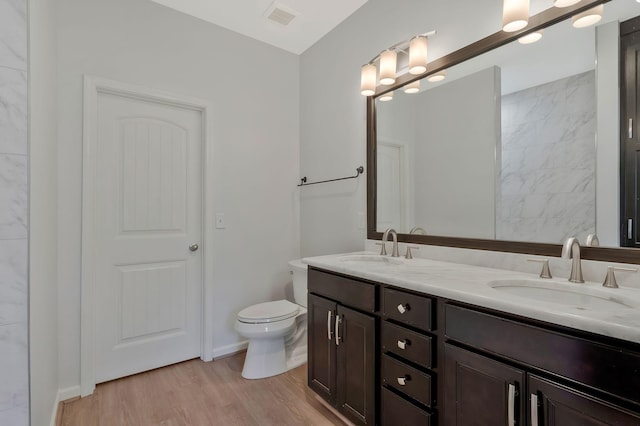 bathroom featuring wood-type flooring, toilet, and vanity