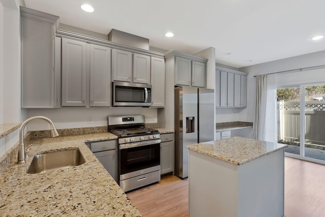 kitchen featuring sink, light stone counters, appliances with stainless steel finishes, and gray cabinetry