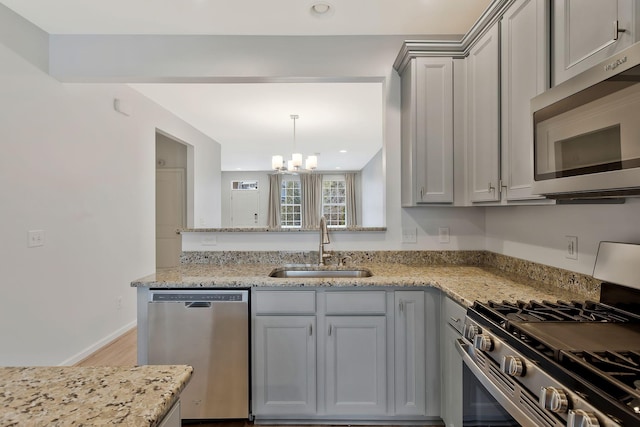 kitchen featuring light stone counters, sink, gray cabinets, and stainless steel appliances