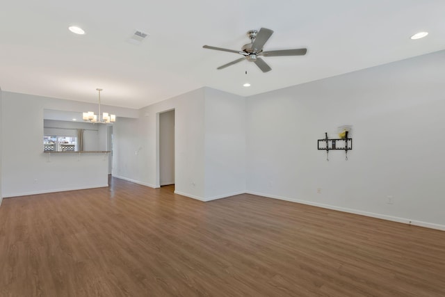 unfurnished living room featuring hardwood / wood-style flooring and ceiling fan with notable chandelier