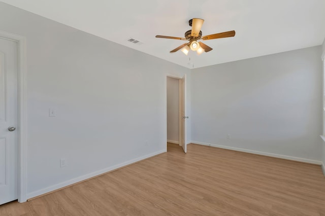 empty room with ceiling fan and light hardwood / wood-style flooring