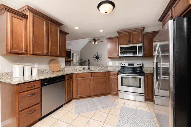 kitchen with ceiling fan, sink, light stone countertops, appliances with stainless steel finishes, and light tile patterned floors