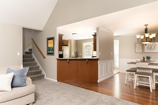 living room featuring vaulted ceiling, an inviting chandelier, and dark hardwood / wood-style floors