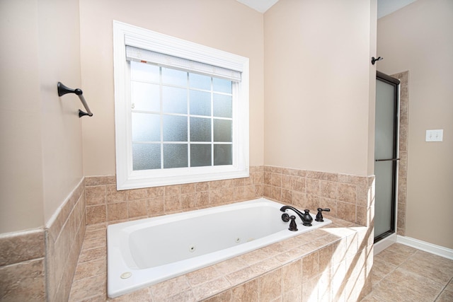 bathroom featuring a stall shower, a jetted tub, and tile patterned floors