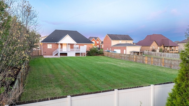 yard at dusk with a fenced backyard and a residential view