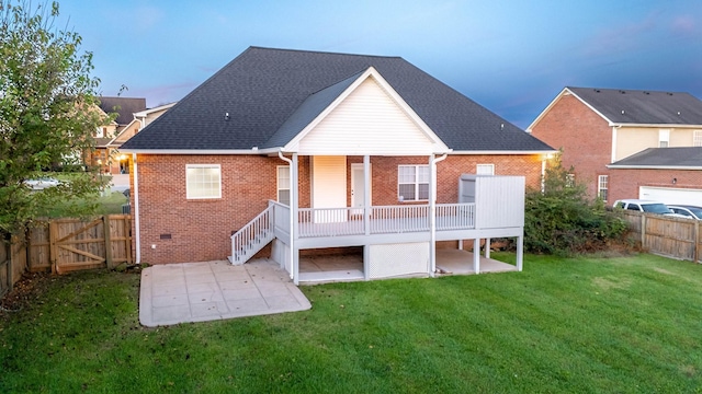 rear view of house featuring brick siding, a fenced backyard, a lawn, and a patio