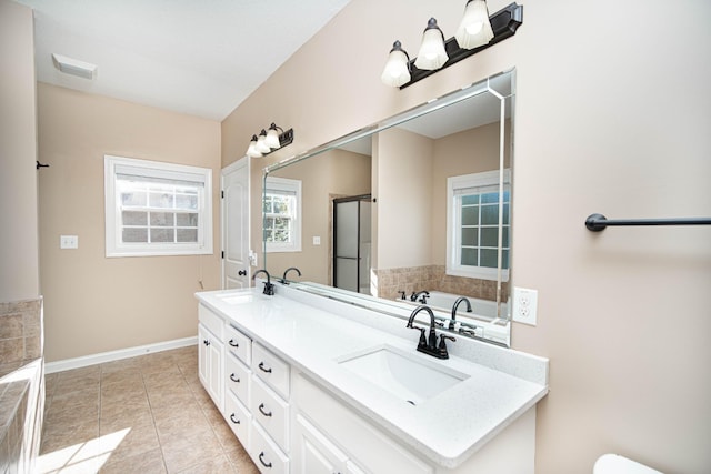 bathroom with a stall shower, tile patterned flooring, a sink, and double vanity