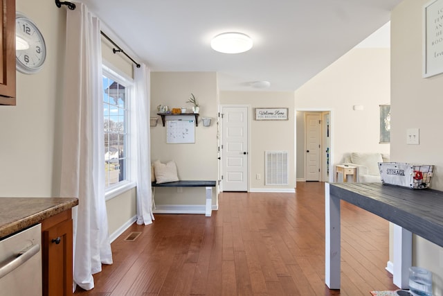 hall with a wealth of natural light and dark hardwood / wood-style flooring