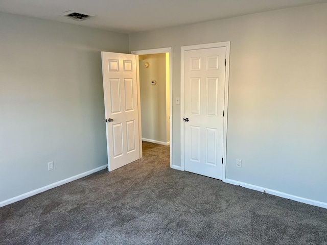 empty room featuring dark colored carpet