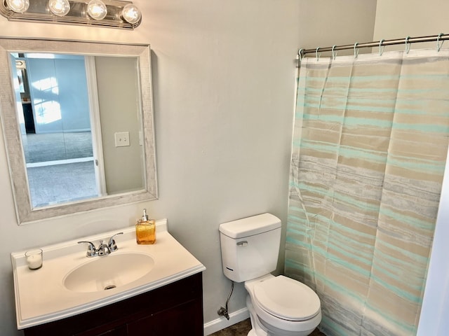 bathroom with toilet, vanity, and curtained shower