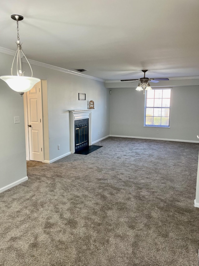 unfurnished living room featuring dark colored carpet, ornamental molding, and ceiling fan