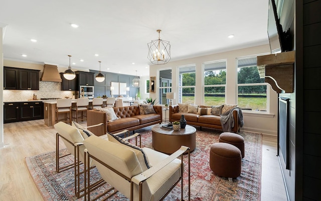 living room with light wood-type flooring and an inviting chandelier