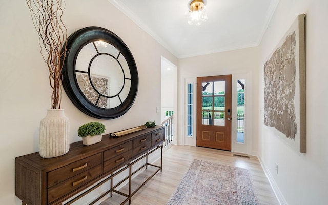 entryway with ornamental molding and light hardwood / wood-style floors