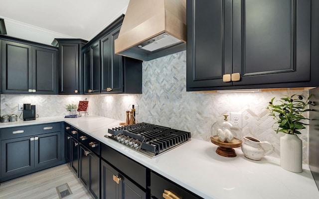 kitchen with premium range hood, stainless steel gas cooktop, ornamental molding, and backsplash