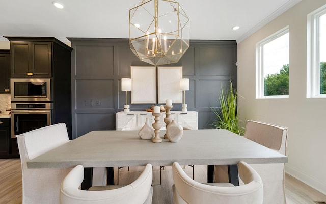 dining space featuring a notable chandelier, crown molding, and light hardwood / wood-style floors