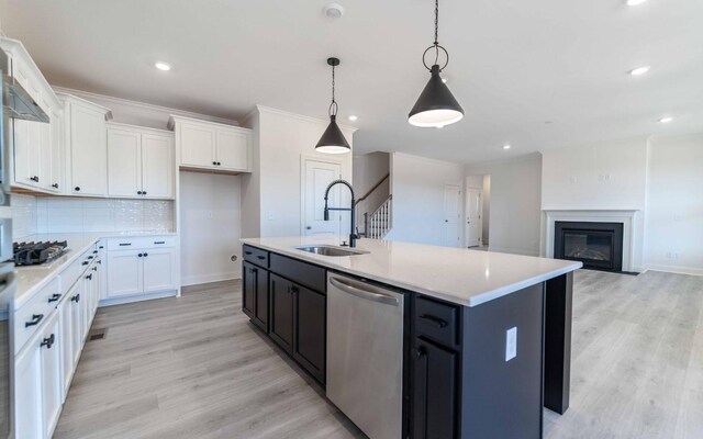 7934 Pine St, Fairview, TN 37062 - kitchen featuring appliances with stainless steel finishes, a sink, white cabinets, light countertops, and tasteful backsplash