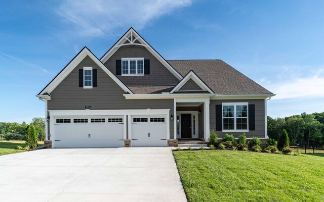 7934 Pine St, Fairview, TN 37062 - craftsman-style house with driveway, a front yard, an attached garage, and a shingled roof