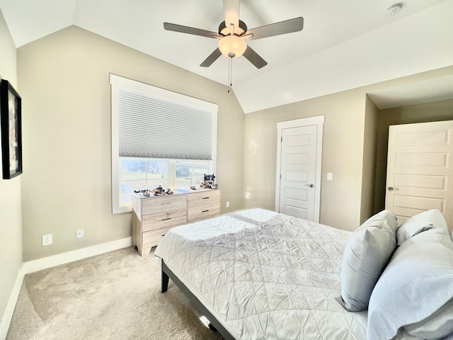 carpeted bedroom with ceiling fan and vaulted ceiling