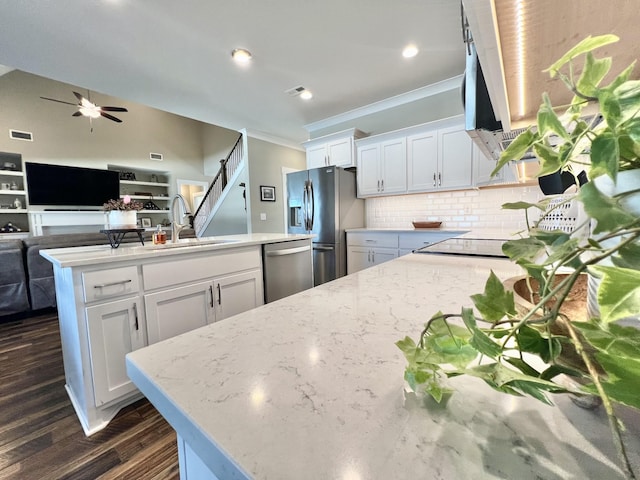 kitchen featuring light stone countertops, white cabinetry, stainless steel appliances, tasteful backsplash, and sink