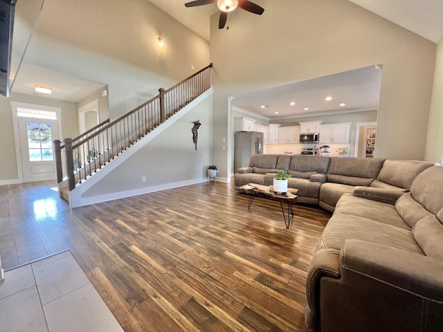 living room with ceiling fan, wood-type flooring, and high vaulted ceiling