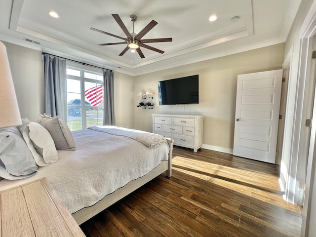 bedroom with dark hardwood / wood-style floors, ceiling fan, ornamental molding, and a raised ceiling