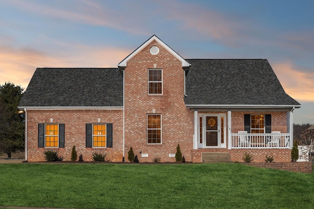 view of front of house with a porch and a yard