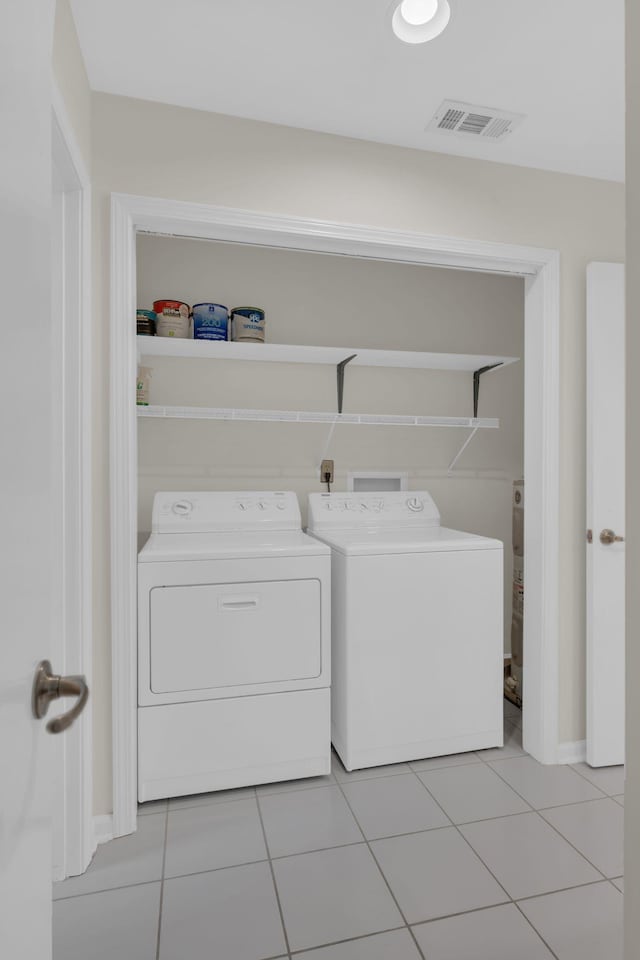 washroom featuring light tile patterned floors and washing machine and clothes dryer