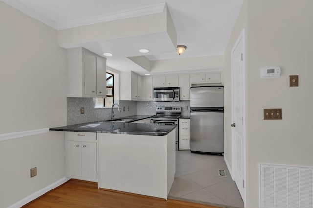 kitchen with tasteful backsplash, sink, crown molding, appliances with stainless steel finishes, and white cabinets