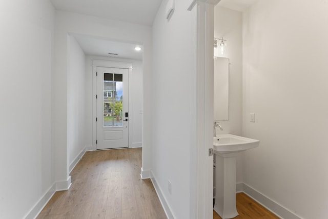 hall featuring sink and light hardwood / wood-style floors