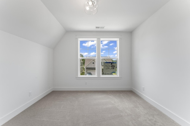 additional living space with light carpet and vaulted ceiling