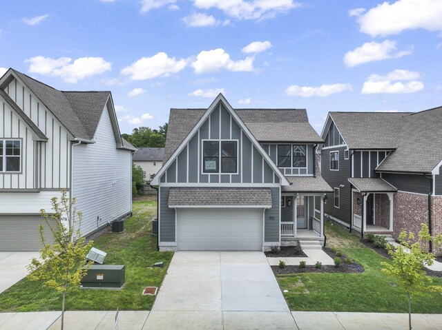 english style home with a garage, a front yard, and central AC