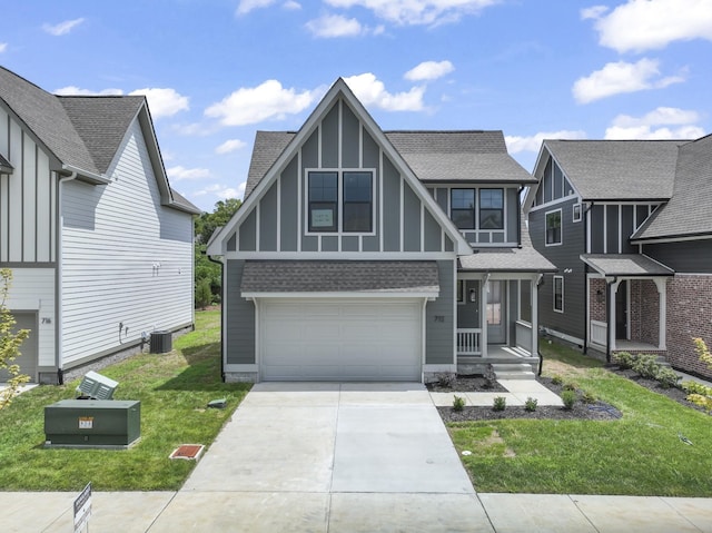 english style home featuring a front yard, cooling unit, and a garage