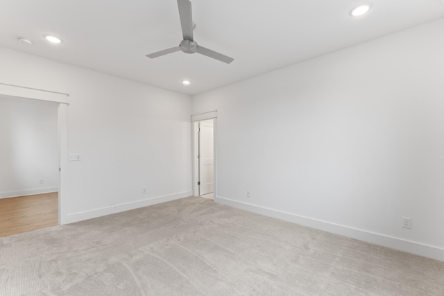 empty room with ceiling fan and light colored carpet