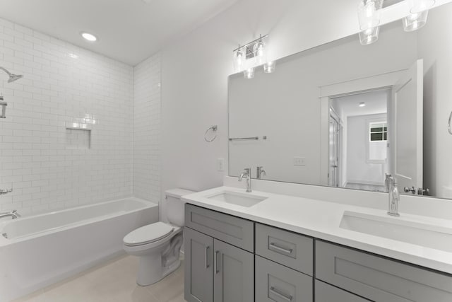 full bathroom with tiled shower / bath, tile patterned floors, vanity, and toilet