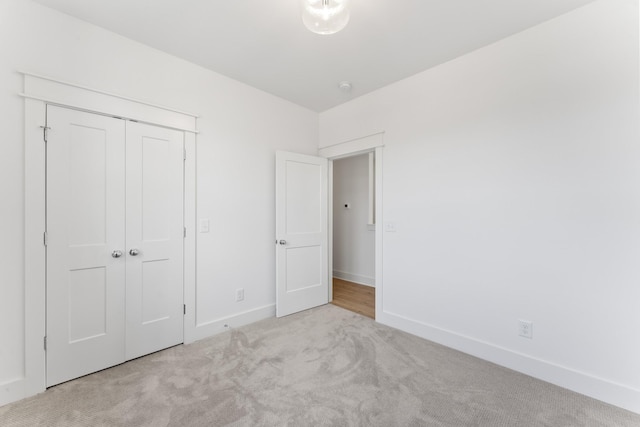 unfurnished bedroom featuring a closet and light carpet