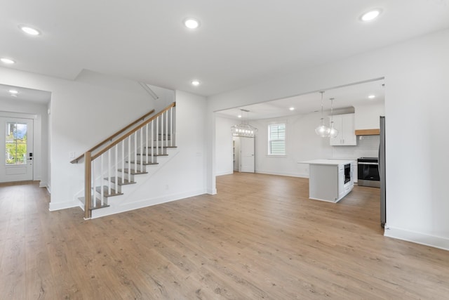 unfurnished living room featuring a healthy amount of sunlight and light hardwood / wood-style floors