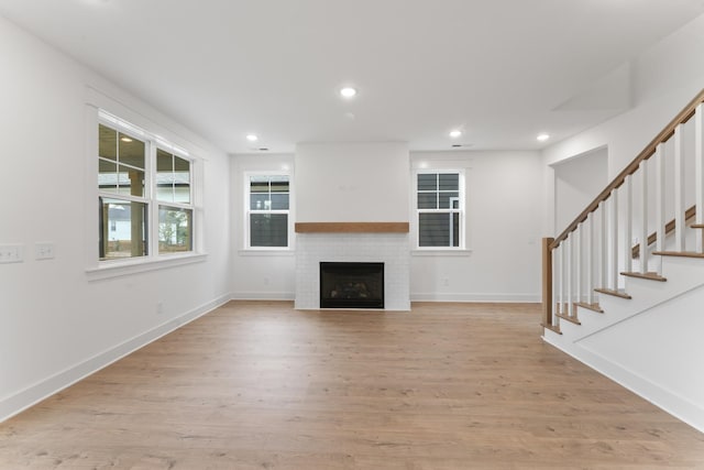 unfurnished living room featuring a large fireplace and light wood-type flooring