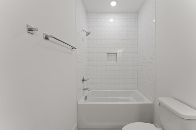 bathroom featuring toilet and tiled shower / bath combo