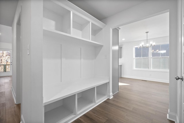 mudroom with hardwood / wood-style flooring and a chandelier